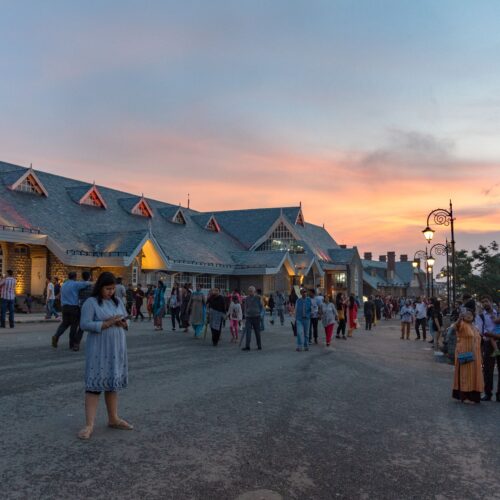 Evening scene with people near Indian landmark during sunset.