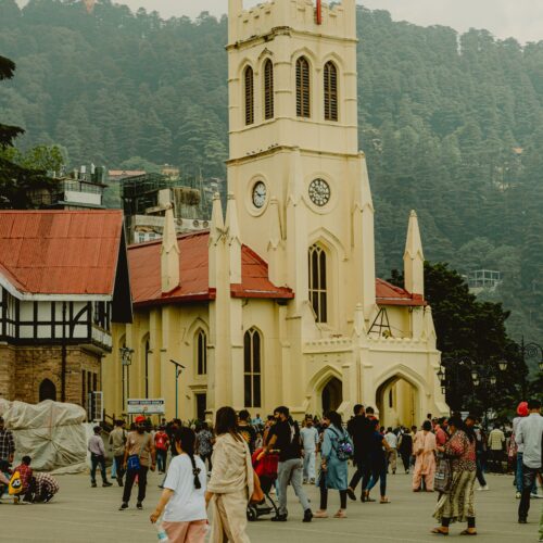 Bustling scene at Christ Church, Shimla, India showcasing local architecture and culture.