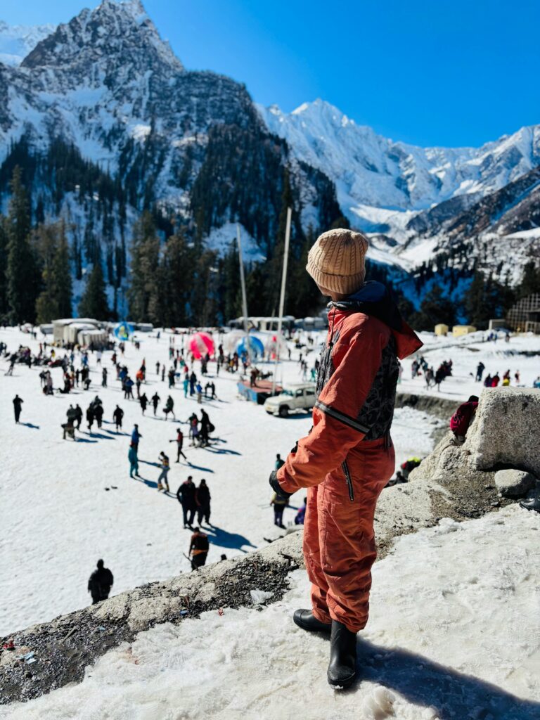 People enjoying winter sports against the stunning backdrop of the Himalayas.